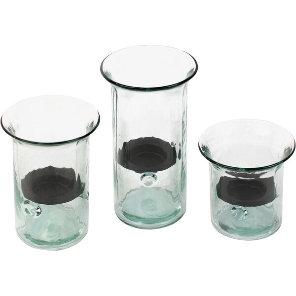 Three glass cylindrical hurricane candle holders with black metal inserts.