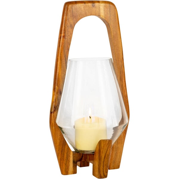 A Kalalou wooden oval candle holder with a glass hurricane over a lit candle.