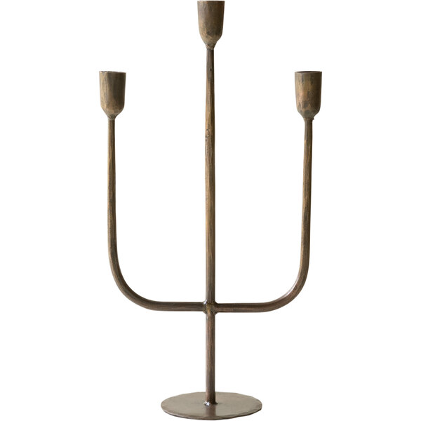An antique brass metal candelabra with three candles on it.