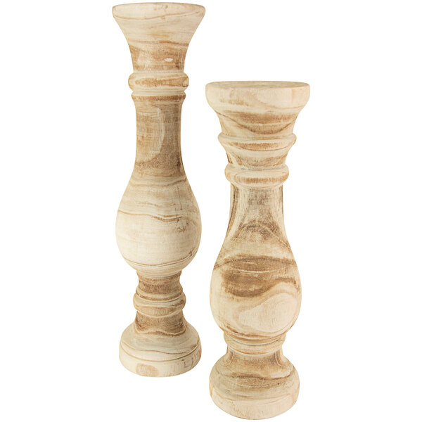 A pair of wooden candlesticks with carved details.