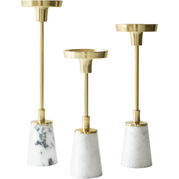 A group of Kalalou marble and brass candle holders on a table.