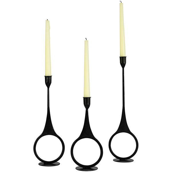 A group of white candles in black Kalalou ring candle holders.