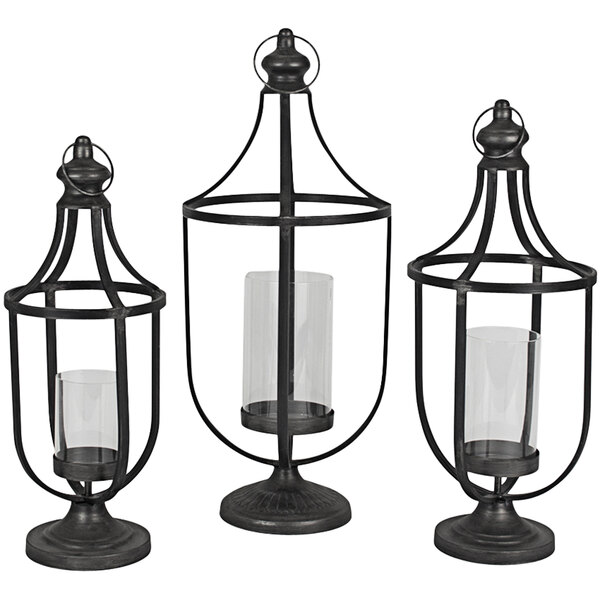 A group of three black metal Kalalou lanterns with glass candle holders.