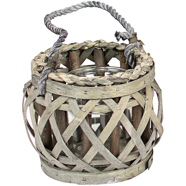 A wicker basket with a glass candle holder inside.