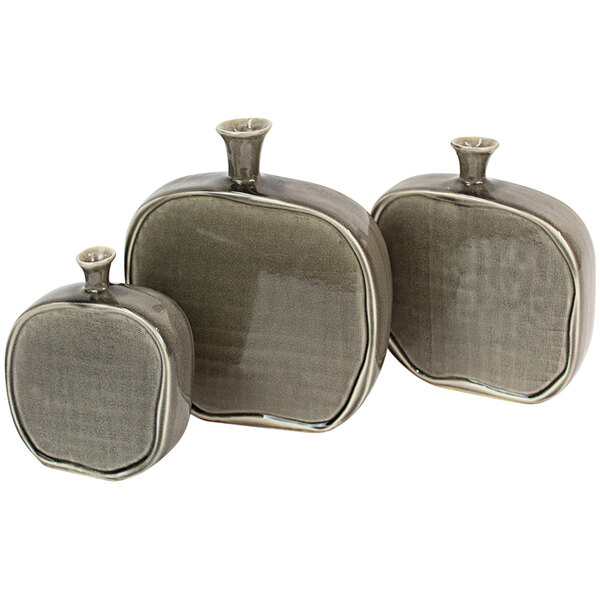A group of three gray ceramic flat bottles with handles.