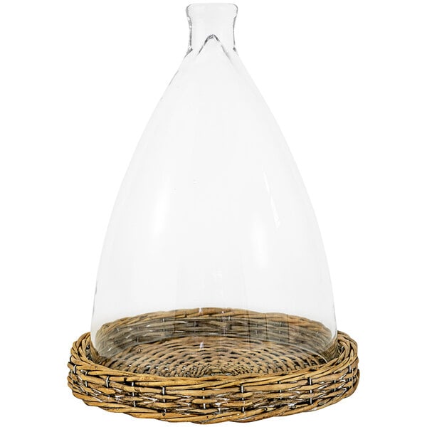A clear glass cloche with a wicker base.