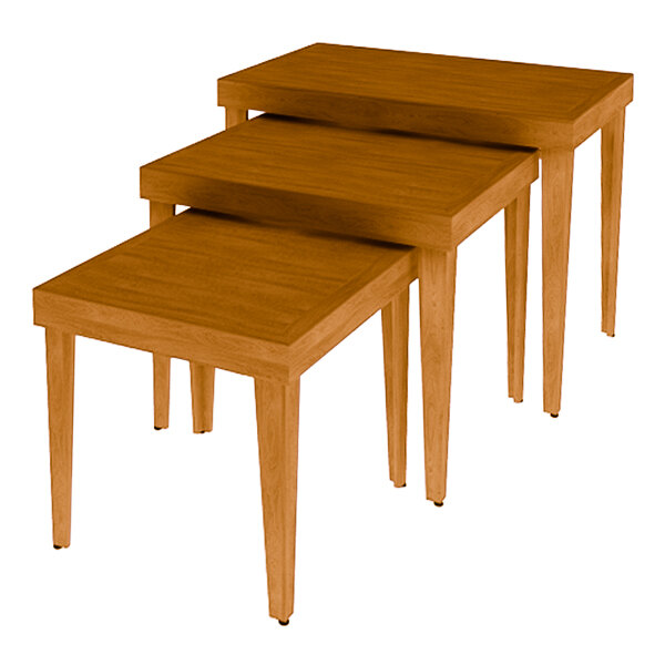 A stack of Marco Company Honey Pine wooden nesting tables with legs.