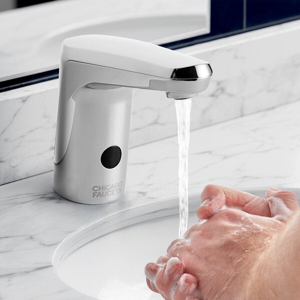 A person washing their hands under a Chicago Faucets E-Tronic touchless faucet.