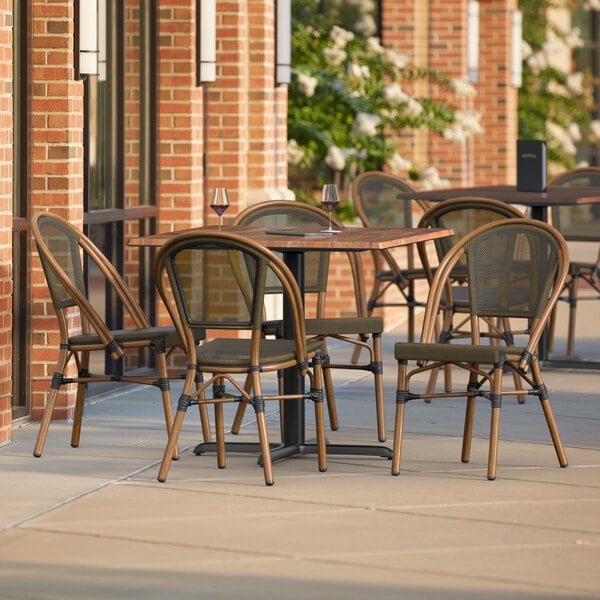 A Lancaster Table & Seating Yukon Oak table with 4 brown French bistro chairs on an outdoor patio.