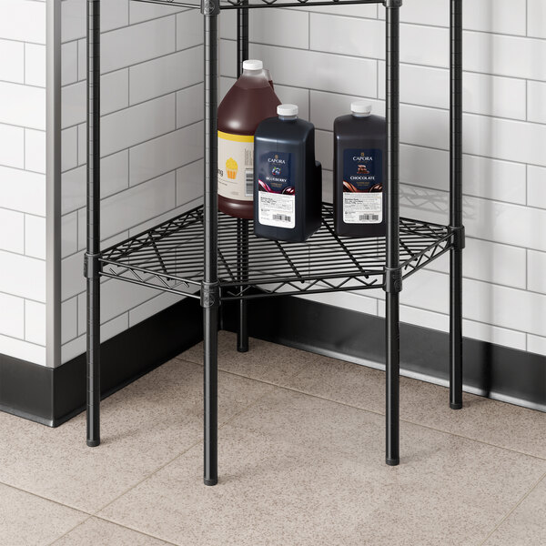 A black epoxy wire pentagon corner shelf designed for storage.