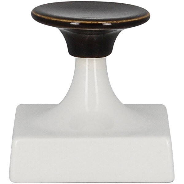 A white pedestal with a black and gold rimmed knob.