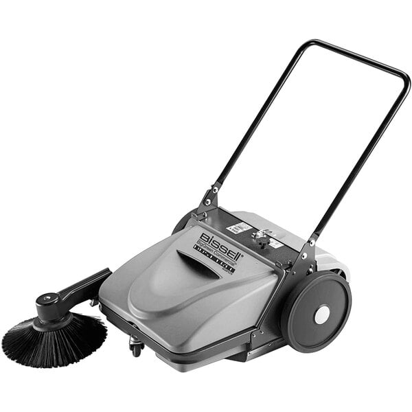 A Bissell commercial floor sweeper with a handle.