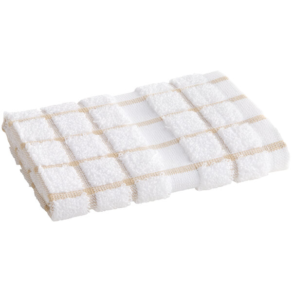 A white dish cloth with tan windowpane squares and a white stripe.