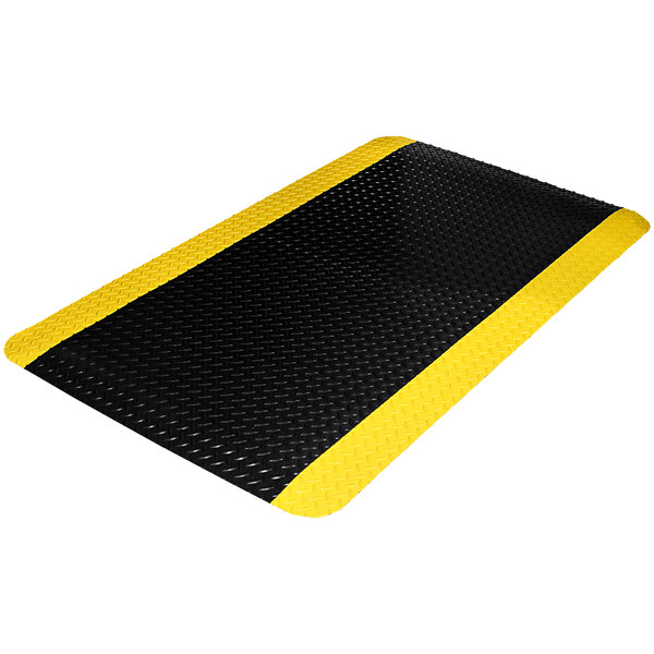 A black Diamond Dek sponge mat with yellow borders and a diamond pattern.