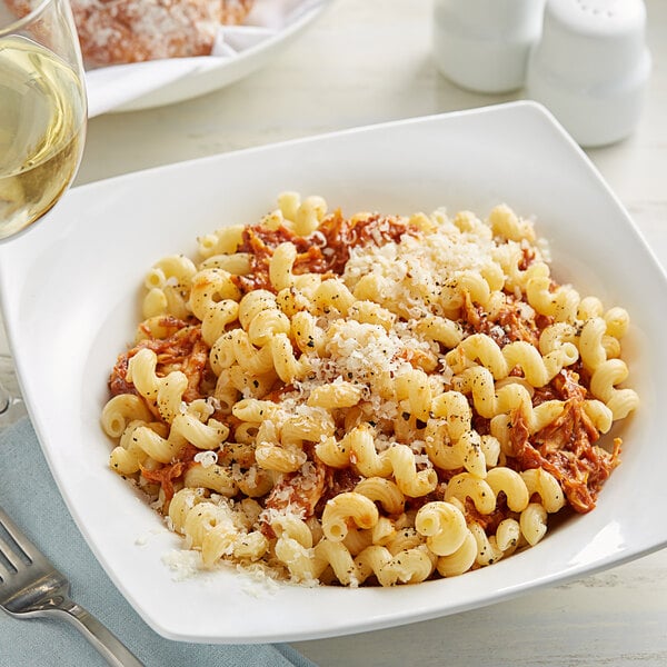 A white plate of Barilla Cellentani pasta with a fork.