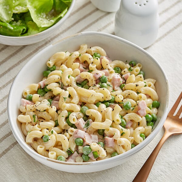 A bowl of Barilla elbow pasta with peas.