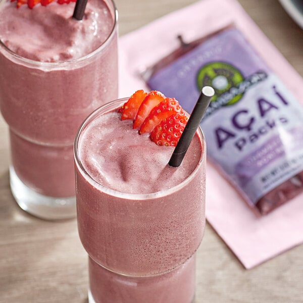Two glasses of pink smoothies made with Sambazon Unsweetened Organic Acai, with strawberries and straws.