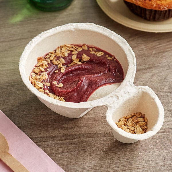 A bowl of acai with oat flakes and a wooden spoon.
