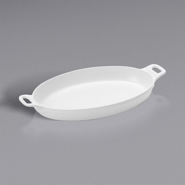 An American Metalcraft white oval melamine casserole dish with two handles on a gray surface.