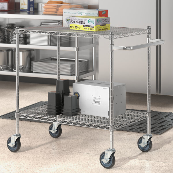 A Regency chrome utility cart with shelves and a U-shaped handle holding white boxes.