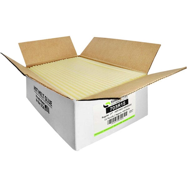 A white box with yellow strips containing tan Surebonder glue sticks.