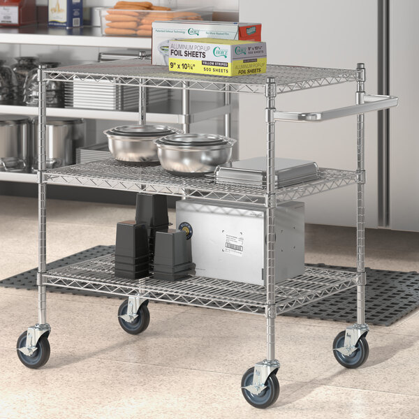 A Regency chrome utility cart with food containers on metal shelves.
