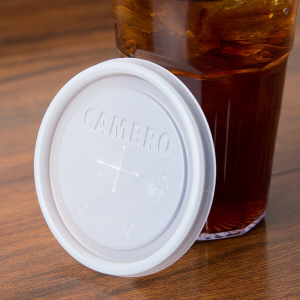 A translucent Cambro lid on a glass of brown liquid.