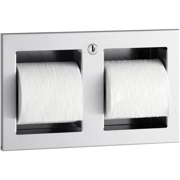 A Bobrick stainless steel double toilet paper roll holder with two rolls of toilet paper.
