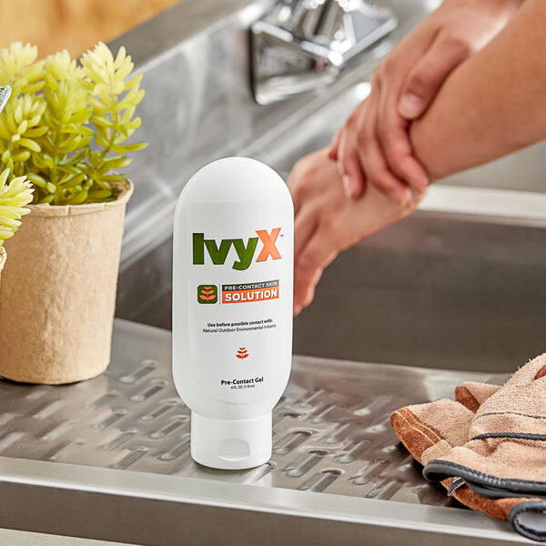 A person washing their hands in a sink using IvyX Pre-Contact Skin Solution.