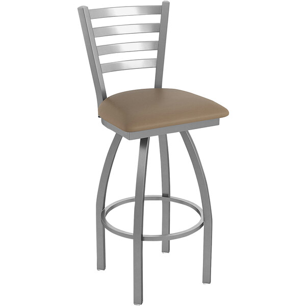 A Holland Bar Stool stainless steel outdoor extra tall bar stool with a tan cushioned seat.