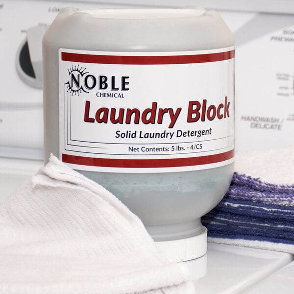 A white container of Noble Chemical concentrated solid laundry detergent with a red label.