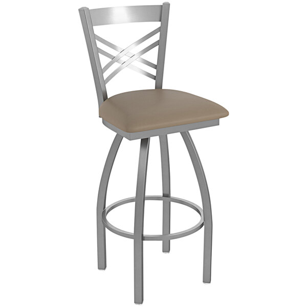 A Holland Bar Stool stainless steel swivel outdoor bar stool with a tan cushion.