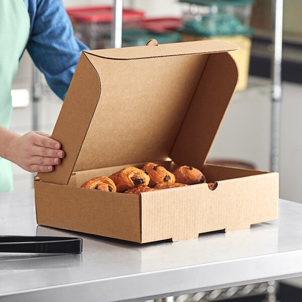 A person holding a Choice corrugated catering box of pastries.