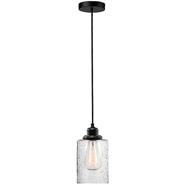 A Globe bronze pendant light with a clear glass shade hanging in a restaurant dining area.