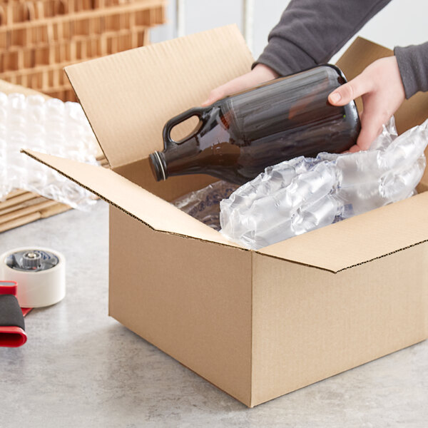 A person opening a Lavex heavy-duty corrugated shipping box to reveal a bottle of beer inside.