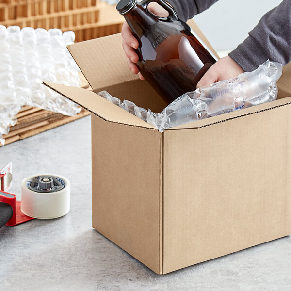 A person holding a bottle of beer in a Lavex Kraft shipping box.