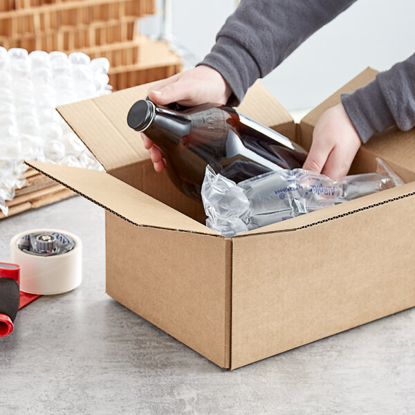 A person opening a Lavex heavy-duty cardboard shipping box with a bottle inside.