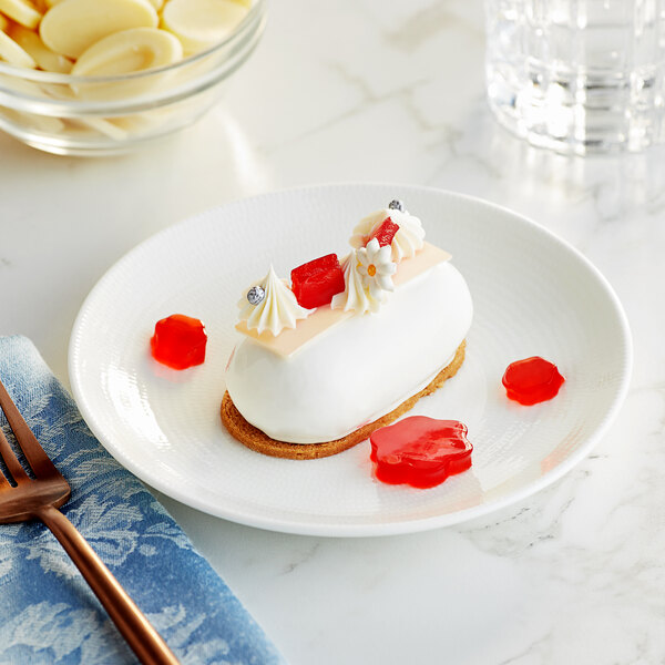 A white dessert with white frosting and red jelly on a plate.