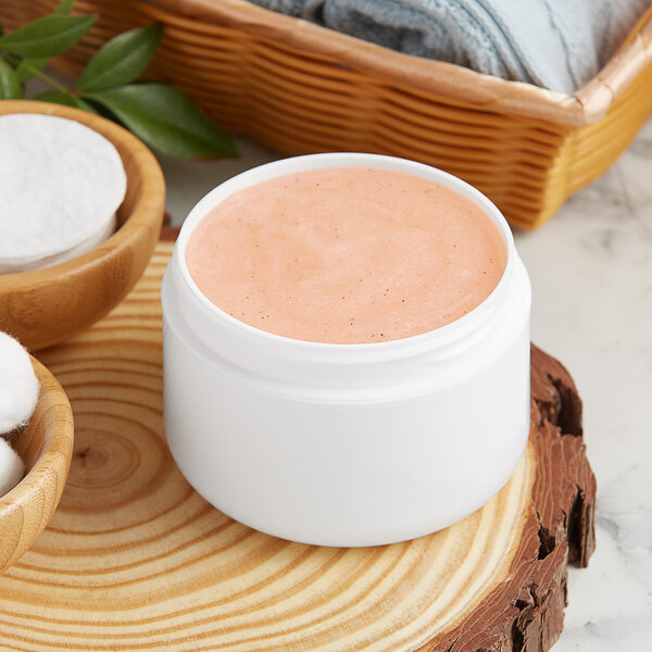 A white container of pink face cream.