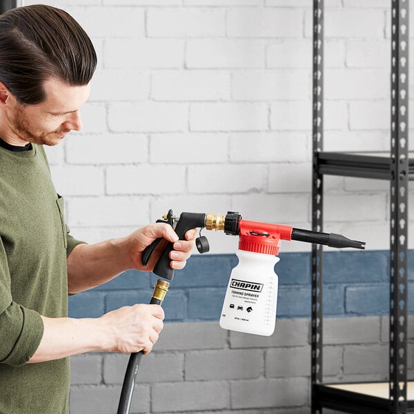 A man using a Chapin handheld sprayer to clean a shelf.