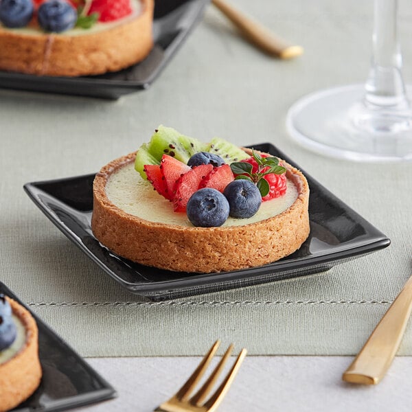 A plate with large round fruit tarts made with La Rose Noire graham cracker tart shells.