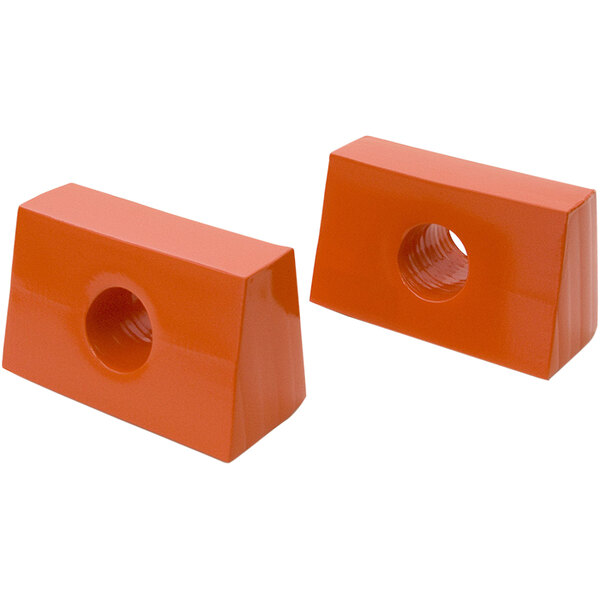 Two orange plastic blocks with holes in them.