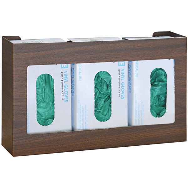 A woodgrain Omnimed glove dispenser with three white boxes of green gloves inside.