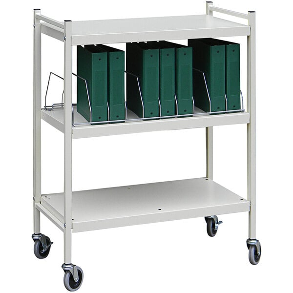 A light gray Omnimed medical cart with green binders on it.