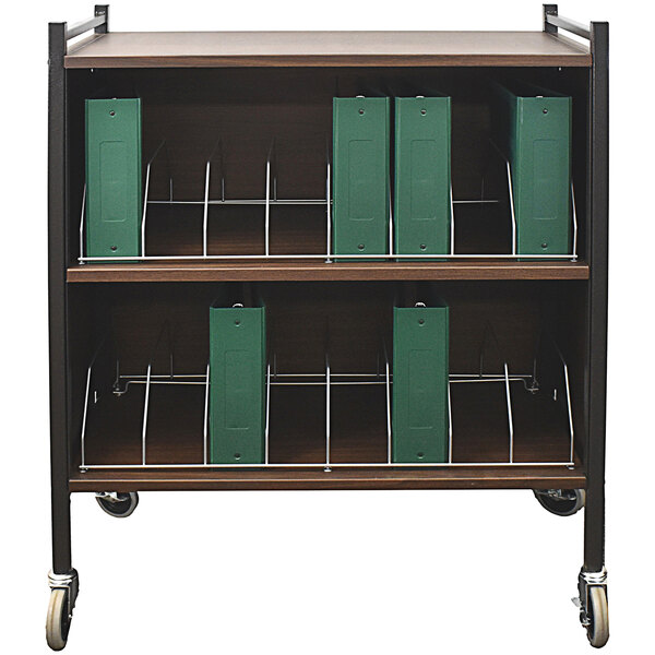An Omnimed woodgrain medical cart with green binders on it.