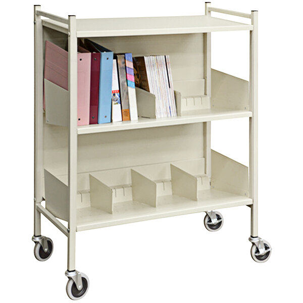 An Omnimed beige metal cart with 2 shelves holding books.