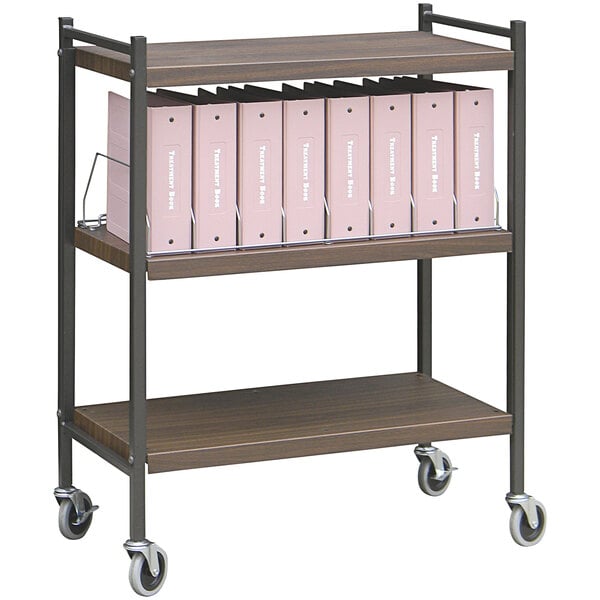 An Omnimed woodgrain rolling cart with shelves holding binders.