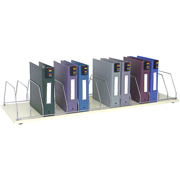 A beige Omnimed countertop storage rack with 15 sections holding blue, purple, and grey binders.