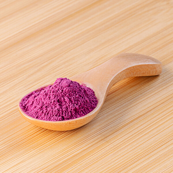 A wooden spoon with Dragon Fruit Powder on it.