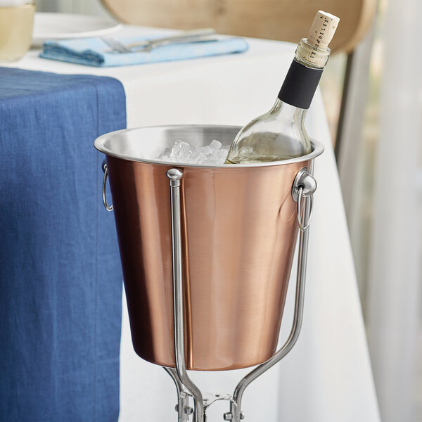 An Acopa copper wine bucket with a bottle of wine in ice.